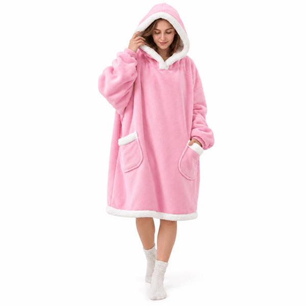 Vrouw met capuchon op in een lange roze Snuggle hoodie deken met twee teddy zakken