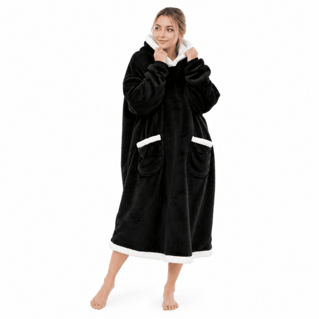 Vrouw in een lange zwarte Snuggle hoodie deken met witte sherpa kraag en zakken
